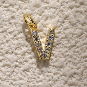 Detailweergave van een vergulde letter V-bedel met zirkonia voor sieraden maken