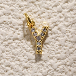 Detailopname van vergulde letter Y-hanger met zirkonia-inleg en ophangoog