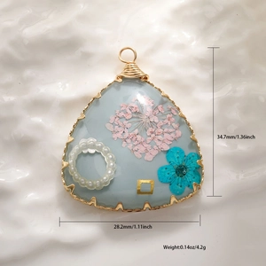 Macro shot of triangle resin flower pendant with size specs and gold wire wrap details
