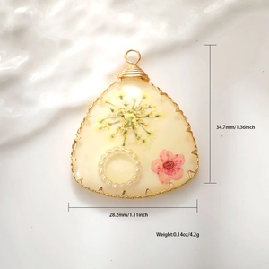 Detail of triangle resin pendant with dried flowers and copper wire wrap 34.7mm