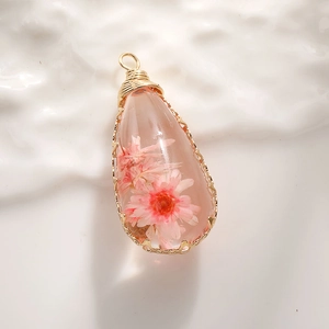 Handmade teardrop resin pendant with real pink daisy flower and gold wire wrapping