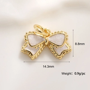 Macro shot of gold-plated bow charm with pink enamel and size details 14.3mm by 8.8mm