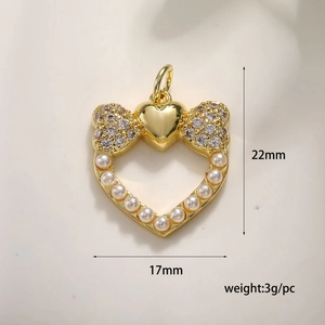 Detail view of a gold heart pendant with zircon bow and pearls measuring 22mm by 17mm
