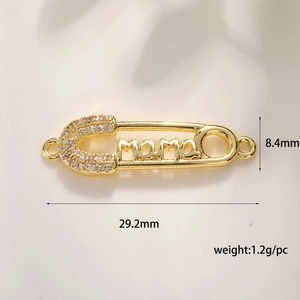 Detail of 18K gold plated safety pin pendant with mama lettering and zircon stones