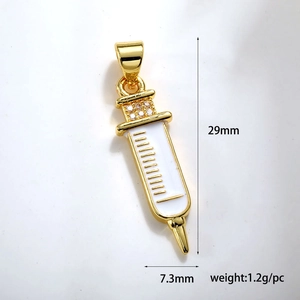 Detailed macro of a gold medical syringe pendant with white enamel and rhinestone inlay