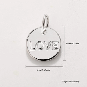 Macro detail of silver 'LOVE' engraved pendant with dimensions 9mm and 0.8g weight