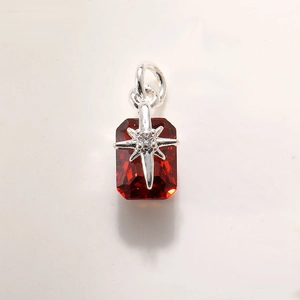 Macro view of a rectangular red crystal pendant with a silver star-shaped setting and bail