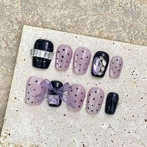 Handmade purple cat-eye press-on nails with 3D bows and rhinestones on stone background