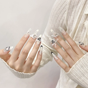 Handmade pearl white press-on nails with lace bows, black hearts, and silver chain accents