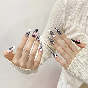 Handmade long stiletto press-on nails with pink spiders, bows, and spider web nail art