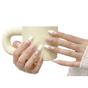 French nude press-on nails with white butterfly patterns and delicate pearl accents