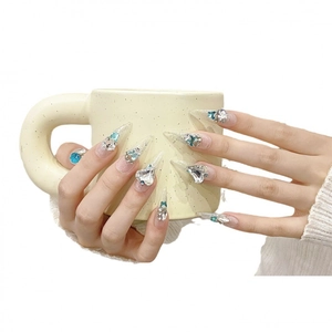 Unghie a stiletto fatte a mano con cristallo a cuore blu e glitter argento su base nude