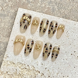 Handmade leopard print press-on nails with amber gold foil and 3D metal chain details