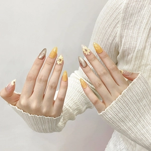 Hand-painted sunflower press-on nails in long stiletto shape with yellow floral designs