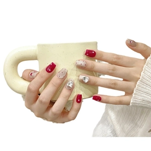 Faux ongles faits main avec pois rouges, étoiles et strass en cœur sur pointes carrées
