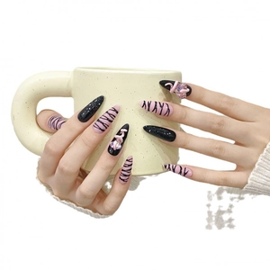 Pink zebra print press-on nails with 3D heart and snake charms on long pointed tips