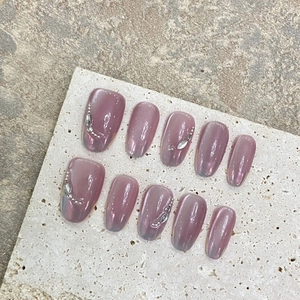 Handmade mauve cat eye press-on nails with oval shape and sparkling rhinestone accents