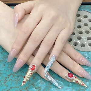 Detail of luxury press-on nails with vintage metal relief and colorful rhinestones