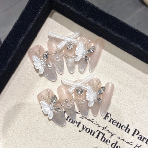 French cat-eye press-on nails with white 3D butterflies and pearls in a display box