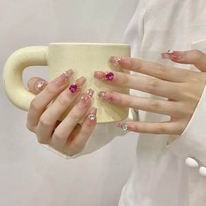 Detail of pink cat-eye press-on nails with 3D rose hearts and bows on long coffin shape