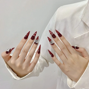 Faux ongles stiletto faits main rouge foncé avec lignes argentées et strass brillants