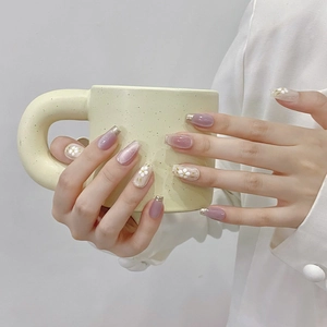 Pink and lavender cat eye press-on nails with white flower nail art and golden French tips