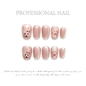 Detail of pink cat eye press-on nails with 3D cat paw, bear art and red bow accents