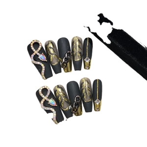 Dark style handmade press-on nails with golden snake charms and metal chain design