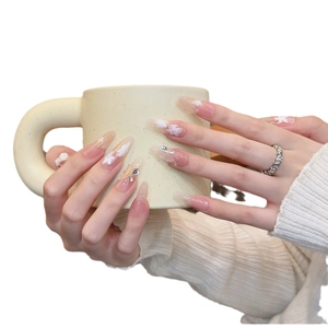 Faux ongles amande rose dégradé avec fleurs 3D, motifs papillon et strass brillants