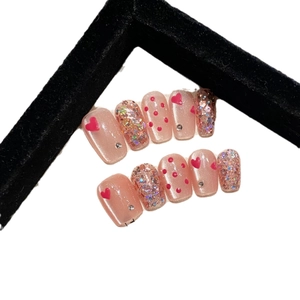 Handmade cat-eye press-on nails with pink glitter, red hearts and sparkling crystals
