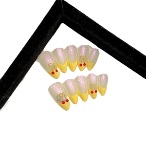 Handmade press-on nails with pearl luster, yellow French tips and cherry 3D charms