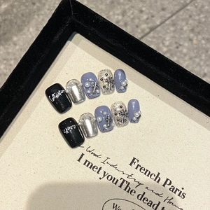 Handmade press-on nails with silver mirror finish, black base, pearls, and metal crosses