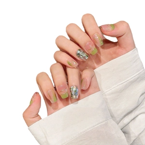 Faux ongles courts carrés vert frais et rose nude avec lignes dorées et paillettes