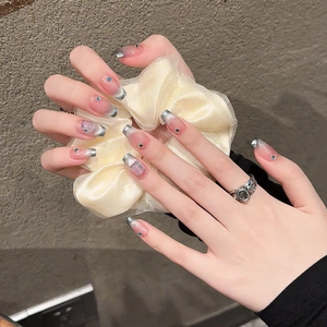 French smile cat-eye press-on nails with silver metallic edges and blue rhinestones