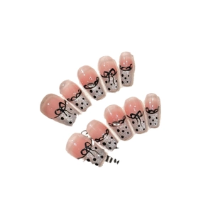Pink and silver glitter press-on nails with black polka dots and bows in a chic style