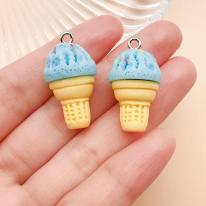Detail view of blue resin ice cream cone charms with silver rings held in hand