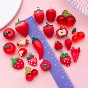 Macro view of resin fruit charms showing detailed strawberry and cherry pendants