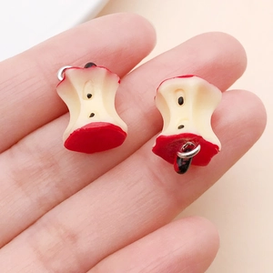 Macro view of handmade realistic red resin apple core pendants with metal loops