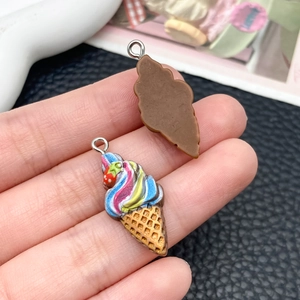 Vue détaillée des pendentifs fraise en résine avec crochets en métal pour création DIY