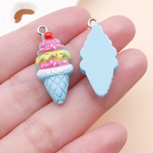 Macro detail of strawberry ice cream resin charm with pink cream and blue cone base