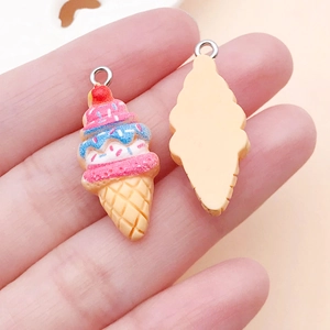 Hand holding a colorful DIY resin strawberry ice cream pendant for craft accessory making