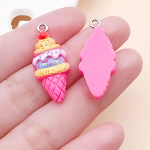 Macro detail of resin strawberry ice cream charms with pink cones and cherry accents