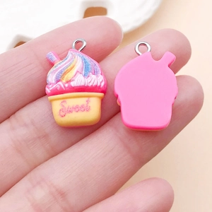 Vista dettagliata di ciondoli cupcake in resina rosa con vortice arcobaleno e ganci in metallo