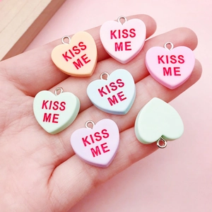 Detail von herzförmigen Kiss Me Harzanhängern in Pastellfarben mit Metallringen