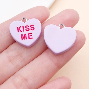 Detail von herzförmigen Lavendel-Resin-Anhängern mit rotem KISS ME Text für DIY-Schmuck