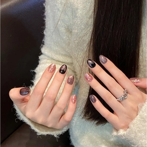 Pink cat eye press-on nails with glitter accents and heart rhinestones in oval shape