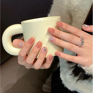 Short square aurora cat eye press-on nails with silver butterfly charms on soft pink base