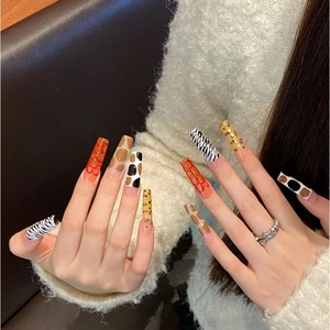 Long coffin press-on nails featuring mixed animal prints like zebra, leopard, and cow patterns