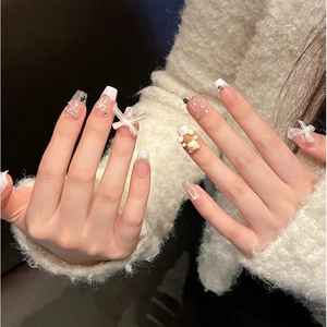 Handmade press-on nails in nude pink featuring 3D bows, bear charms and French tips