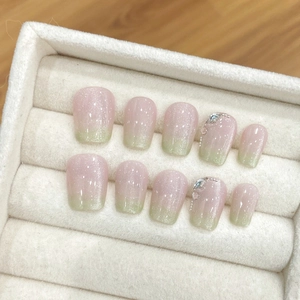 Unghie finte cat-eye rosa e verdi con strass in una scatola di velluto elegante
